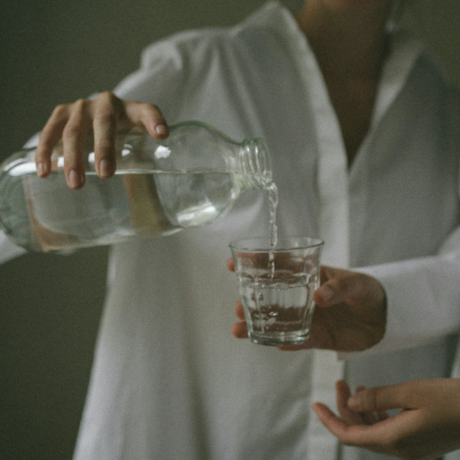 Hand som häller vatten