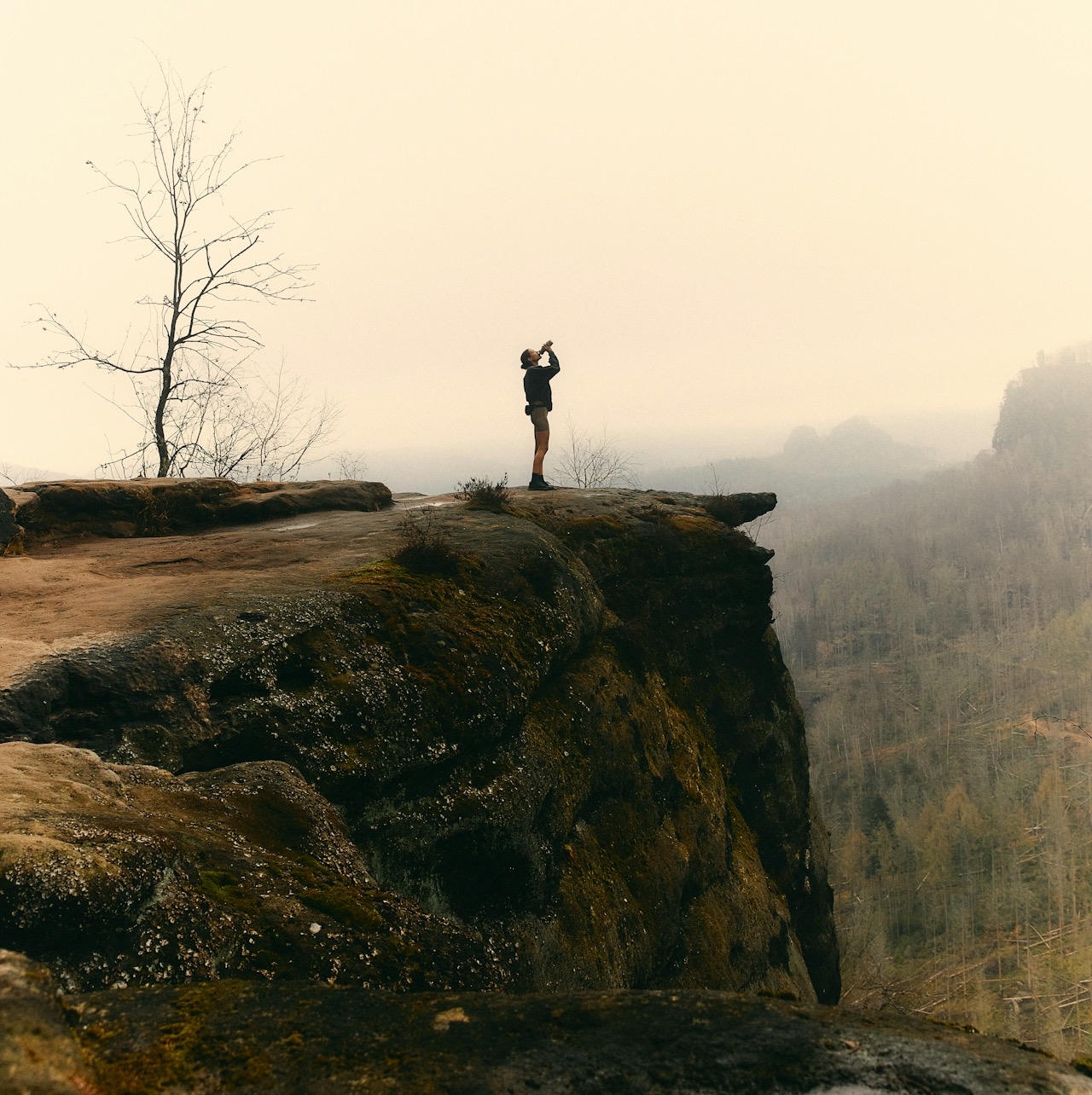Människa som dricker vid en klippavsats